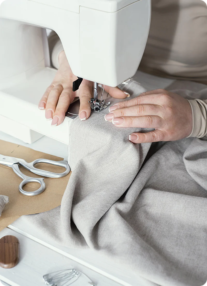 Hands stitching fabric on a sewing machine